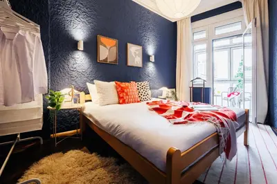 a bedroom with a large bed with a blue wall at Fireplace Magic 108m2 with Balcony & Foosball in Belgrade