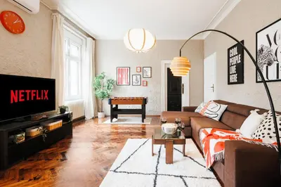 a living room with a couch and a tv at Fireplace Magic 108m2 with Balcony & Foosball in Belgrade