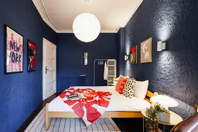 a blue bedroom with a bed and a blue wall at Fireplace Magic 108m2 with Balcony & Foosball in Belgrade