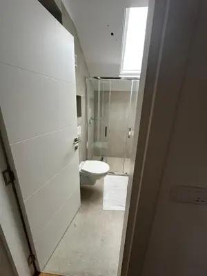 a white bathroom with a toilet and a window at Apartment 6 Belgrade in Belgrade