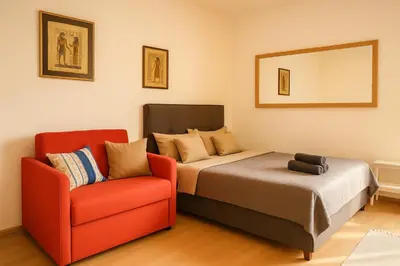 a bedroom with a bed and a red chair at Republic square central in Belgrade