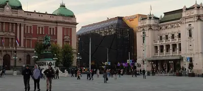 a group of people walking around a city square at Republic square central in Belgrade