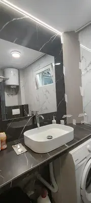 a bathroom with a white sink and a mirror at Republic square central in Belgrade
