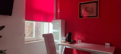a room with a red wall with a table and a window at Republic square central in Belgrade
