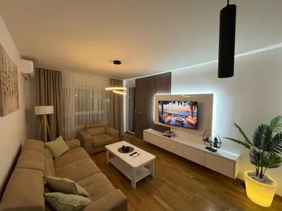 a living room with a couch and a tv at La Homa LUX in Pančevo