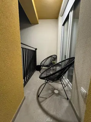 two chairs sitting on the balcony of a building at La Homa LUX in Pančevo