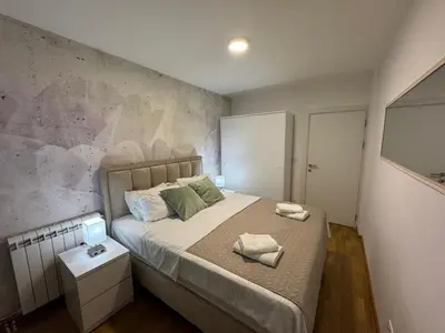 a bedroom with a bed with two towels on it at La Homa LUX in Pančevo