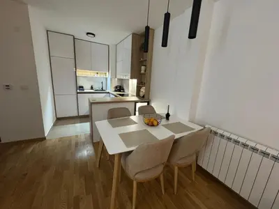 a kitchen and dining room with a table and chairs at La Homa LUX in Pančevo