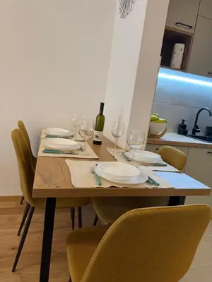 a wooden table with plates and wine glasses on it at Fagus apartments in Arandjelovac