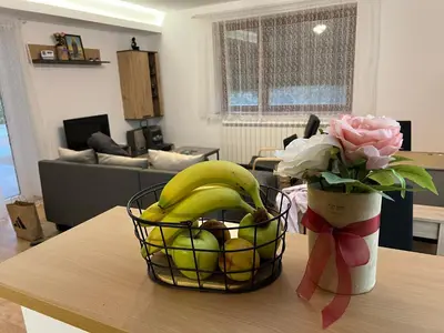 a basket of bananas and a vase of flowers on a table at Countryside rest house in Novi Banovci