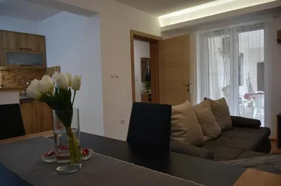a living room with a couch and a table with flowers at Countryside rest house in Novi Banovci