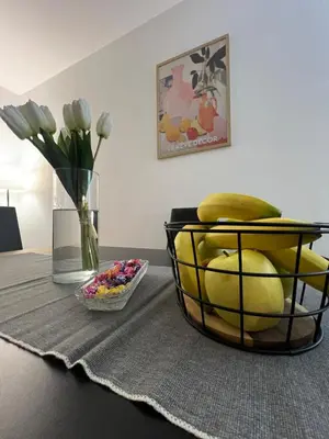 a basket of fruit on a table with a vase of flowers at Countryside rest house in Novi Banovci