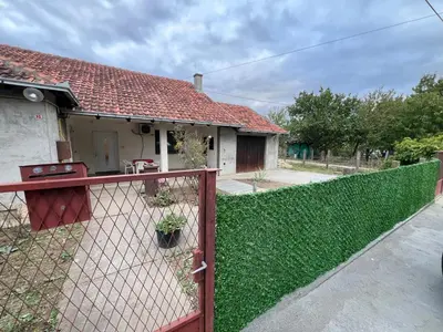 a fence in front of a house with a yard at Countryside rest house in Novi Banovci