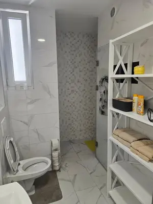 a white bathroom with a toilet and a sink at Miss Extra LuX in Mladenovac