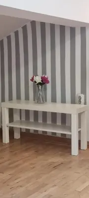 a white bench with a vase of flowers on it at IVA Apartman in Belgrade