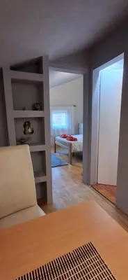 a room with a bed and a room with a chair at IVA Apartman in Belgrade