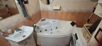 a bathroom with a white tub and a sink at IVA Apartman in Belgrade