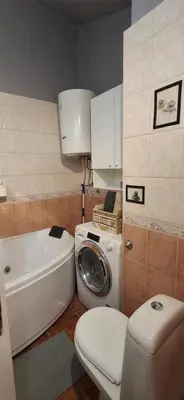 a bathroom with a toilet and a washing machine at IVA Apartman in Belgrade