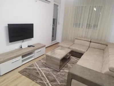 a living room with a couch and a flat screen tv at Apartman Lazar in Ruma