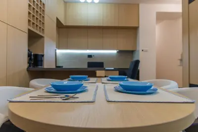 a wooden table with blue bowls and silverware on it at lux Apartman lazar in Pančevo