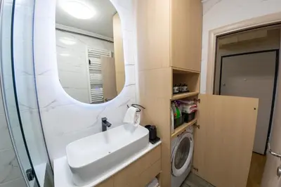 a bathroom with a sink and a washing machine at lux Apartman lazar in Pančevo