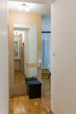 a room with a mirror and a table and a stool at lux Apartman lazar in Pančevo