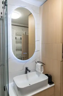 a bathroom with a white sink and a mirror at lux Apartman lazar in Pančevo