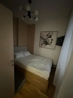 a small bedroom with a bed and a ceiling fan at lux Apartman lazar in Pančevo