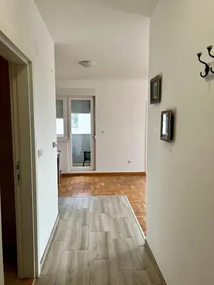 an empty room with white walls and a wooden floor at Apartman Kalina in Belgrade