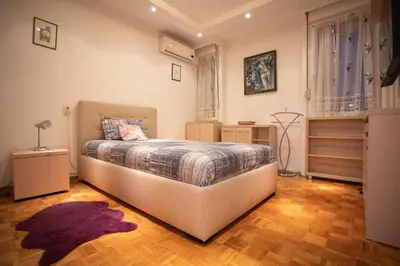 a bedroom with a large bed and a wooden floor at Echo Arena in Belgrade