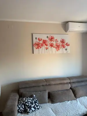 a living room with a couch and a painting of flowers at Kutak mira in Belgrade