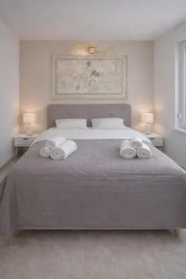 a bedroom with a large bed with towels on it at AeroLux Apartments-Surčin, Near Belgrade Airport in Surčin