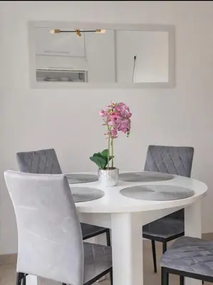 a white table with chairs and a vase of flowers on it at AeroLux Apartments-Surčin, Near Belgrade Airport in Surčin