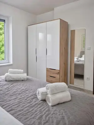 a bedroom with two towels on a bed with a mirror at AeroLux Apartments-Surčin, Near Belgrade Airport in Surčin