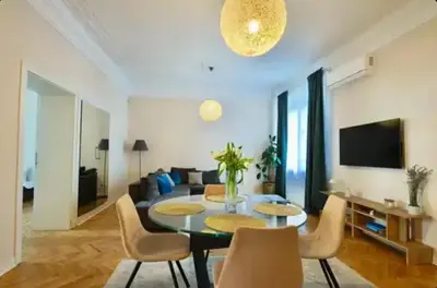 a living room with a table and chairs and a couch at Central Harmony Apartments in Belgrade