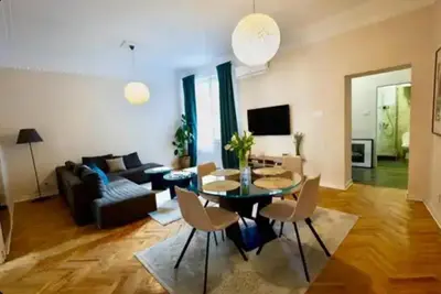 a living room with a table and chairs and a couch at Central Harmony Apartments in Belgrade