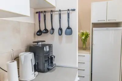 a kitchen with a coffee maker and utensils on the wall at Central Harmony Apartments 1 in Belgrade