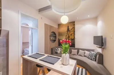 a living room with a couch and a table with flowers at Central Harmony Apartments 2 in Belgrade