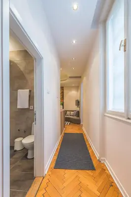 a hallway with a bathroom with a toilet and a window at Central Harmony Apartments 2 in Belgrade