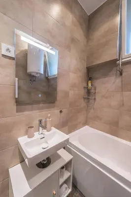 a bathroom with a sink and a tub and a toilet at Central Harmony Apartments 2 in Belgrade