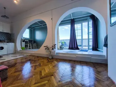 a large living room with a large window and wooden floors at apartment on top of the city in Belgrade