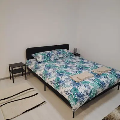a bed in a room with a white wall at Elena Airport Apartments in Surčin