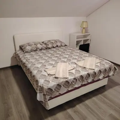 a bedroom with a large bed with towels on it at Elena Airport Apartments in Surčin