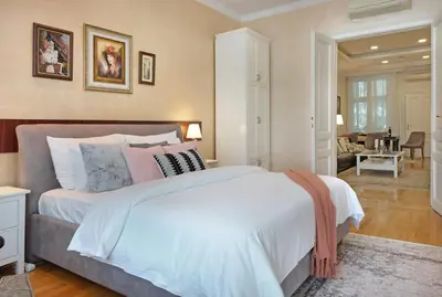 a bedroom with a large bed and a living room at Ambasador&Luxury Downtown apartment in Belgrade