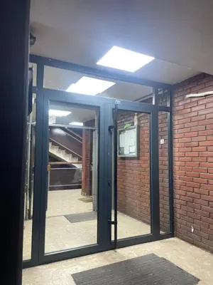 an open glass door in a building with a brick wall at Neja in Belgrade