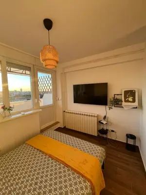 a bedroom with a bed and a flat screen tv at SKY NEST - Small Studio, Grand View in Belgrade