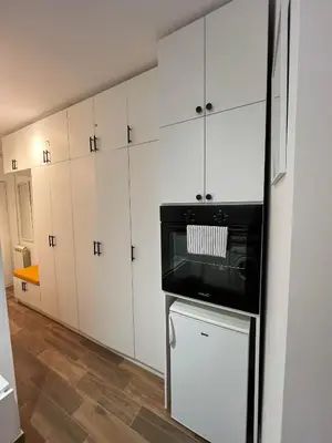 a kitchen with white cabinets and a black microwave at SKY NEST - Small Studio, Grand View in Belgrade