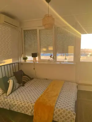 a bedroom with a bed and two windows at SKY NEST - Small Studio, Grand View in Belgrade