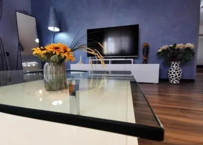 a living room with a glass table with flowers on it at Vila Miona Apartments in Belgrade