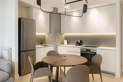 a kitchen with a table and chairs in a room at Belgrade Waterfront - River Residences in Belgrade